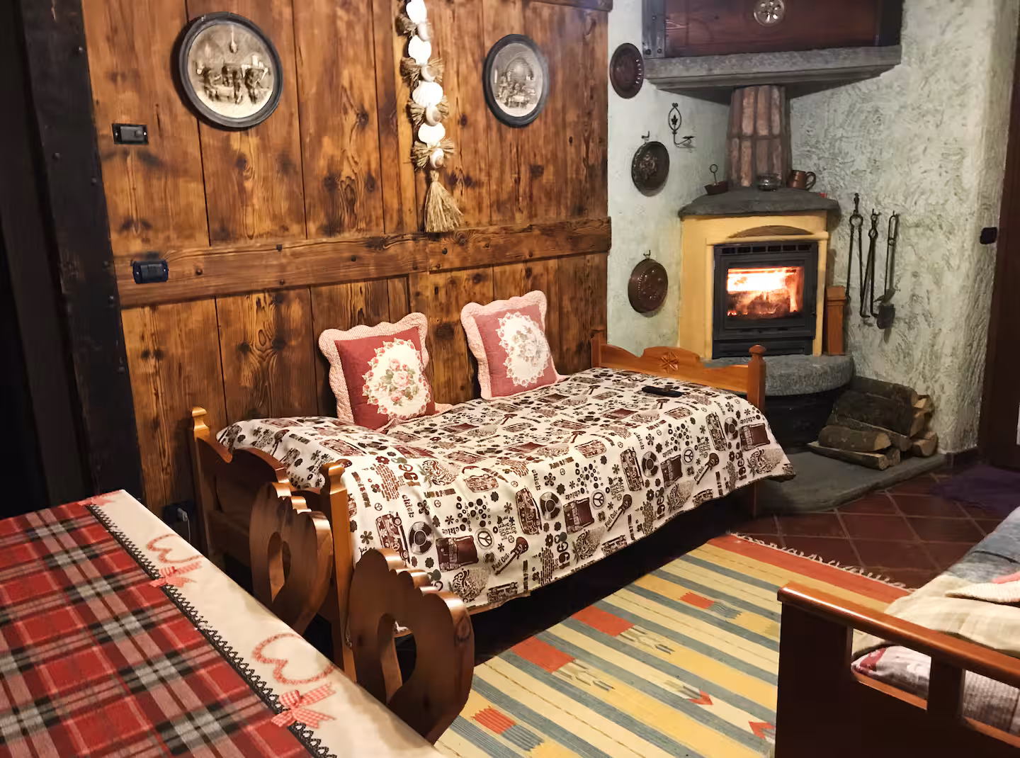 Cosy living area with rustic wooden sofa, stove glow and traditional alpine wall panels